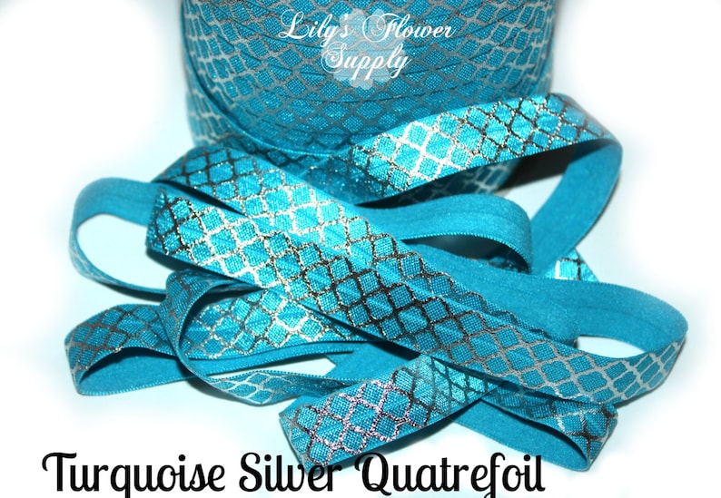 May include: Turquoise blue elastic with a silver quatrefoil pattern.  "Lily's Flower Supply" is printed on the elastic.