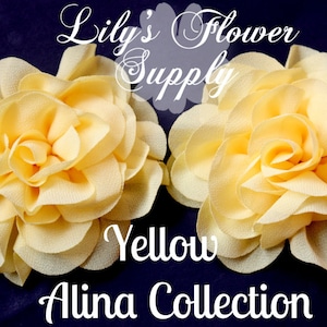 May include: Two yellow fabric flower hair accessories from the Alina Collection. The flowers have multiple layers of petals and are set against a dark blue background. The text "Lily's Flower Supply" and "Yellow" are also visible.