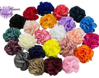 May include: Assortment of 20 handmade fabric flower embellishments in various colors, including red, blue, yellow, pink, white, green, orange, and purple. Each flower is made of multiple layers of fabric, creating a ruffled, voluminous look.