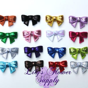 Pode incluir: Conjunto de 16 laços de lantejoulas em várias cores, incluindo laranja, preto, dourado, roxo, verde, rosa, prata, azul, vermelho, marrom e turquesa.  Lily's Flower Supply.