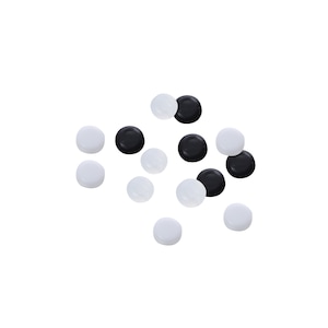 May include: A collection of black and white round game pieces. The pieces are scattered on a white background.