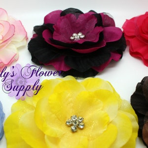 May include: Six fabric flower hair clips in various colors, including pink, red, yellow, blue, brown, and purple. Each flower has a rhinestone center.