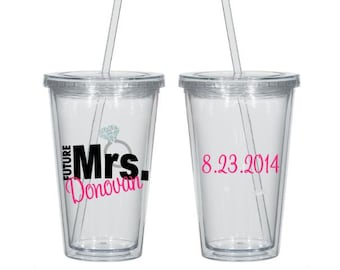 May include: Two clear plastic tumblers with straws. One tumbler has the text "Future Mrs. Donovan" with a diamond ring graphic. The other tumbler has the date "8.23.2014".