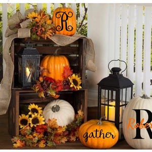 May include: Fall decor with pumpkins, sunflowers, and lanterns. The pumpkins are decorated with the letters "R" and "gather" and the text "Roberts".