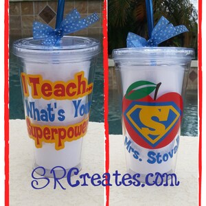 May include: Two clear plastic tumblers with straws and blue and white polka dot bows. One tumbler has the text "I Teach... What's Your Superpower" in yellow, red, and blue. The other tumbler has a red apple with a blue Superman logo and the text "Mrs. Stova" in blue. Both tumblers are on a white surface.