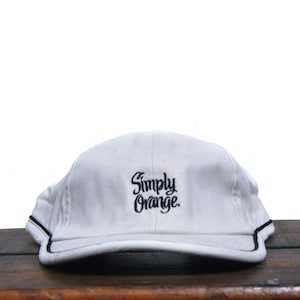 Puede incluir: Gorra de béisbol blanca con un logotipo bordado en negro que dice "Simply Orange."