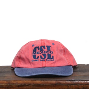 May include: A red and blue baseball cap with the text "CSL MEXICO CSL CABO SAN LUCAS" embroidered on the front.