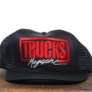 Op de afbeelding: Zwarte truckercap met een rood geborduurd patch waarop "Trucks Magazine" in witte letters staat.