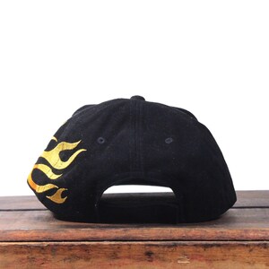 Puede incluir: Gorra de b&eacute;isbol negra con llamas doradas bordadas en el lateral. La gorra est&aacute; hecha de un material suave y tiene una visera curva. Un dise&ntilde;o cl&aacute;sico, adecuado para uso casual.