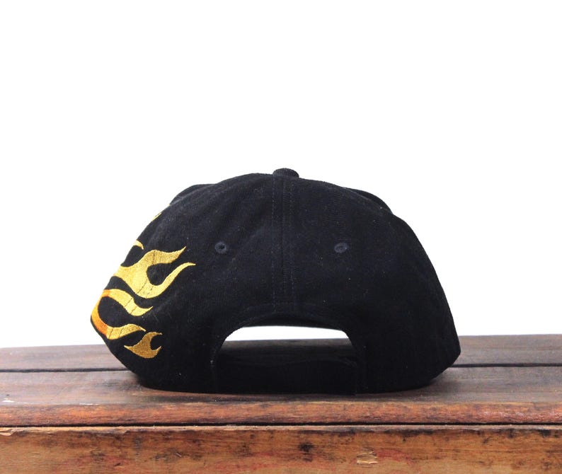 Puede incluir: Gorra de b&eacute;isbol negra con llamas doradas bordadas en el lateral. La gorra est&aacute; hecha de un material suave y tiene una visera curva. Un dise&ntilde;o cl&aacute;sico, adecuado para uso casual.