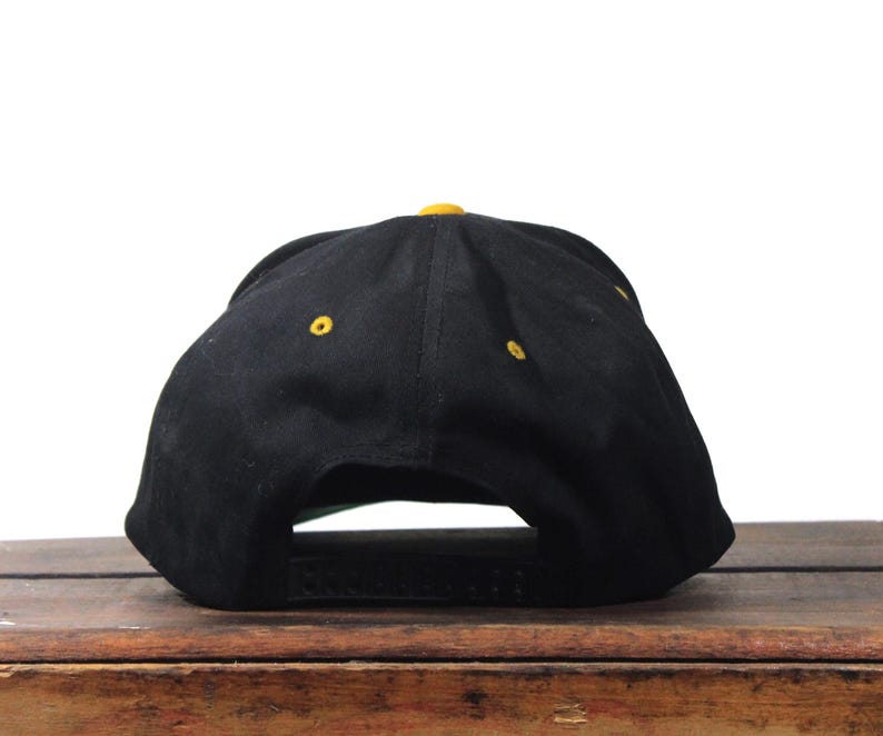 May include: A white ceramic mug with a black handle and the text "But First, Coffee" in a black, handwritten-style font. The mug is on a white surface.