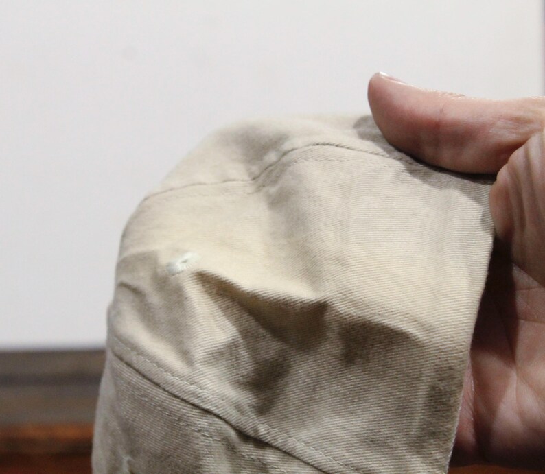 May include: A beige baseball cap with a slight crease on the top. The cap is made of a soft, textured fabric.