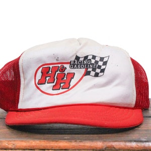 May include: Red and white trucker hat with a red and white logo that says "H&H Racing Gasoline" with a checkered flag.