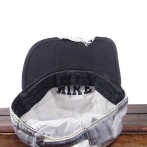 Puede incluir: Una taza de cer&aacute;mica blanca con un asa negra y el texto "But First, Coffee" en negro, con una fuente de estilo manuscrito. La taza est&aacute; sobre una superficie blanca.