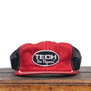 May include: Red and black trucker hat with a white oval patch that says "TECH Tire Repairs".
