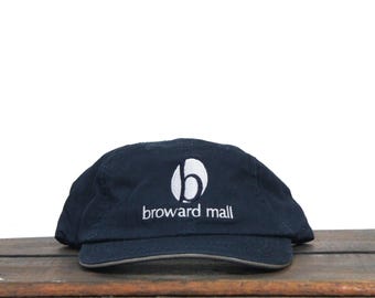 May include: A dark blue baseball cap with a white embroidered logo that says "broward mall" and a white letter "b" inside a circle.