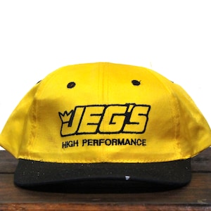May include: A yellow and black baseball cap with the text "JEG'S HIGH PERFORMANCE" embroidered on the front.
