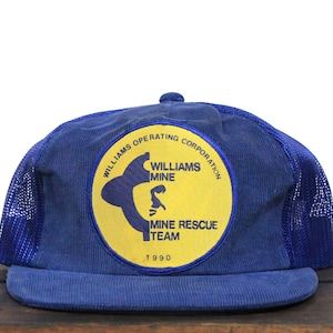 May include: Blue and yellow trucker hat with a patch that reads "Williams Operating Corporation, Williams Mine, Mine Rescue Team, 1990".
