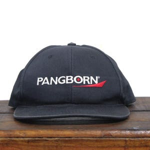 May include: A black baseball cap with a white embroidered logo that reads "PANGBORN" with a red swoosh underneath.