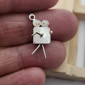 May include: A white ceramic mug with a black handle and the text "But First, Coffee" in a bold, black font. The mug is set against a blurred background, suggesting a cozy setting.