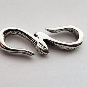Puede incluir: Cierre de plata en forma de serpiente con una superficie texturizada y un sello 925. El cierre est&aacute; dise&ntilde;ado para ser utilizado para joyas u otros accesorios.