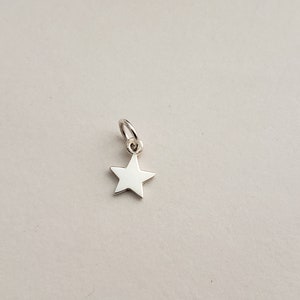 May include: A silver star charm with a loop for attaching to a necklace or bracelet.