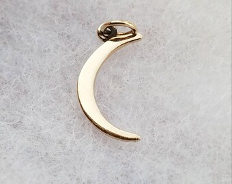 May include: A gold crescent moon charm with a loop for attaching to a necklace or bracelet.