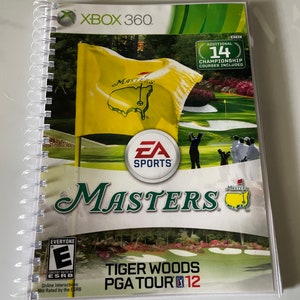 May include: Xbox 360 game case for Tiger Woods PGA Tour 12 featuring a green and white Masters logo with a yellow flag in the background. The game includes 14 additional championship courses.