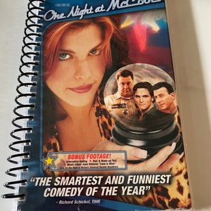 May include: A DVD case for the movie "One Night at McCool's" featuring a photo of Liv Tyler on the front. The case is blue and white with the title of the movie in large, white letters. The case also includes the names of the actors in the movie, including Liv Tyler, Matt Dillon, John Goodman, Paul Reiser, and Michael Douglas. The case also includes the text "The Smartest and Funniest Comedy of the Year" with the name Richard Schickel and the word "TIME" underneath.