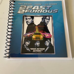 May include: A blue and white movie poster for the film "2 Fast 2 Furious" featuring Paul Walker, Tyrese Gibson, and Eva Mendes. The poster includes the text "High-octane action!"