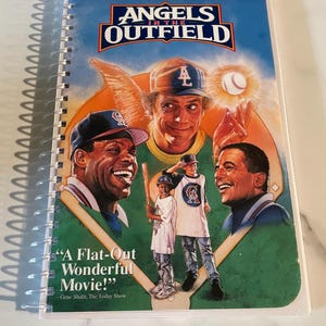 May include: A VHS tape cover for the movie "Angels in the Outfield". The cover features a baseball diamond with three baseball players, including Danny Glover, Tony Danza, and Christopher Lloyd. The text "A Flat-Out Wonderful Movie!" is printed on the cover.