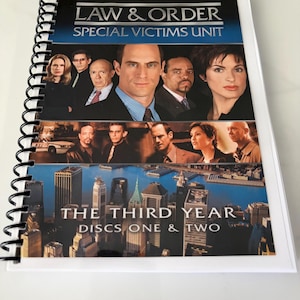 May include: A spiral-bound booklet titled Law & Order Special Victims Unit The Third Year Discs One & Two. The cover features a collage of the cast, a New York City skyline, and the show's logo. The binding is black plastic on the left side.
