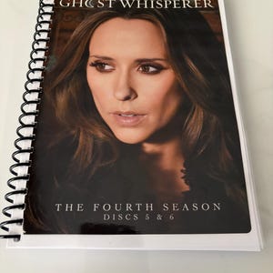 May include: A spiral-bound media case featuring a portrait of Jennifer Love Hewitt on the cover. The text reads JENNIFER LOVE HEWITT, GHOST WHISPERER, THE FOURTH SEASON, and DISCS 5 & 6. The cover has a dark background with a glossy finish.
