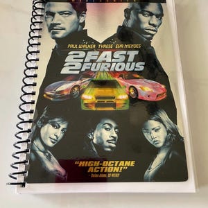 May include: A DVD cover for the movie "2 Fast 2 Furious" featuring Paul Walker, Tyrese Gibson, and Eva Mendes. The cover has a black background with a yellow and red car in the foreground. The text "2 Fast 2 Furious" is in large, white letters.