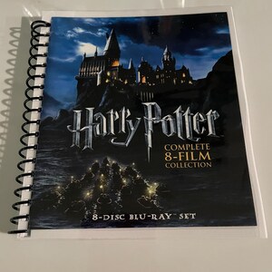 Puede incluir: Un set de Blu-ray encuadernado en espiral de la colección completa de 8 películas de Harry Potter. La portada muestra el castillo de Hogwarts bajo un cielo nocturno. El título "Harry Potter" es plateado. 8 discos Blu-ray.