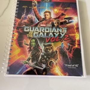 May include: A DVD cover for the movie Guardians of the Galaxy Vol. 2. The cover features the main characters from the movie, including Star-Lord, Gamora, Rocket Raccoon, Groot, and Drax the Destroyer. The cover is red, orange, and blue with a black background.
