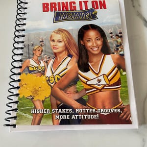 May include: A DVD cover for the movie "Bring It On Again" featuring three cheerleaders in their uniforms. The cheerleaders are smiling and holding pom-poms. The text on the cover reads "Bring It On Again" and "Higher Stakes, Hotter Grooves, More Attitude!"