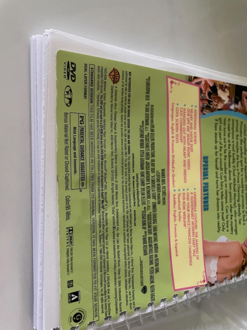 May include: DVD case for the movie "A Cinderella Story" starring Hilary Duff. The back of the case features a list of special features, including a music video, cast commentary, and a behind-the-scenes featurette. The case is rated PG for mild language and innuendo.
