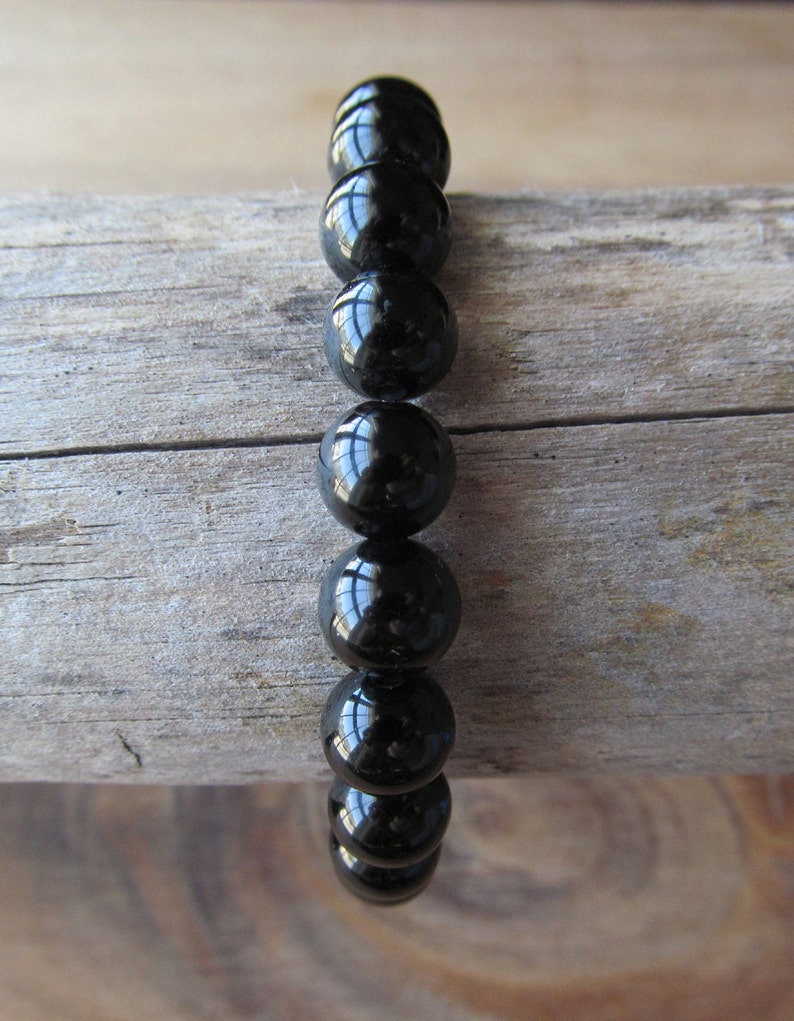 May include: A black beaded bracelet with shiny, round beads.