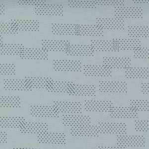 May include: A gray fabric with a subtle pattern of small black dots arranged in a geometric design. The dots are clustered in lines and shapes, creating a modern and abstract look.
