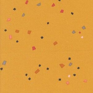 May include: Mustard yellow fabric with a scattered pattern of small, irregular shapes in shades of red, gray, orange, and black. The shapes are randomly distributed across the surface, creating a playful and modern design.
