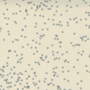 May include: A cream-colored fabric with a scattered pattern of small, dark blue, cross-shaped markings.