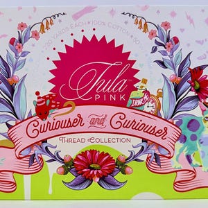 May include: A rectangular box for the Tula Pink Curiouser and Curiouser thread collection. The box features a vibrant illustration of a cat in a top hat, a rabbit, flowers, and a bottle labeled Drink Me, with text reading 220 yards each 100% cotton.