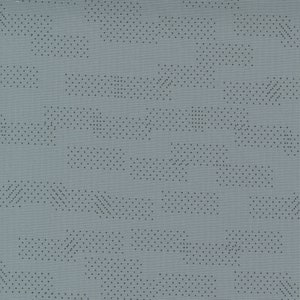 May include: A gray fabric with a subtle pattern of small black dots arranged in geometric shapes. The fabric has a textured surface.