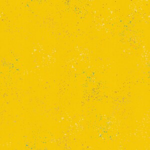 May include: A yellow background with a speckled pattern of small, multi-colored dots.