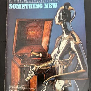 May include: A vintage music book cover titled "Something Old Something New" from the Hal Leonard Organ Adventure Series. The cover features a metallic figure wearing headphones, a wooden cabinet, and a list of songs.