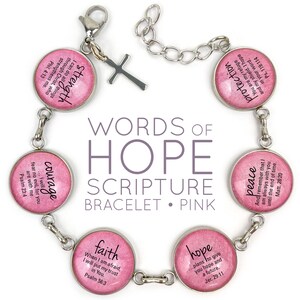 May include: A pink and silver bracelet with charms that have words of hope and scripture verses on them. The charms include "strength", "courage", "faith", "hope", "peace", and "protection".