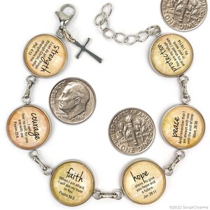 May include: A silver charm bracelet with seven round charms featuring inspirational quotes and bible verses. The charms are decorated with a vintage, distressed look and have a beige background with black text. The bracelet has a silver clasp and a silver cross charm.