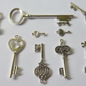 May include: A collection of ten silver-toned skeleton keys with various ornate designs. The keys are arranged on a white background.