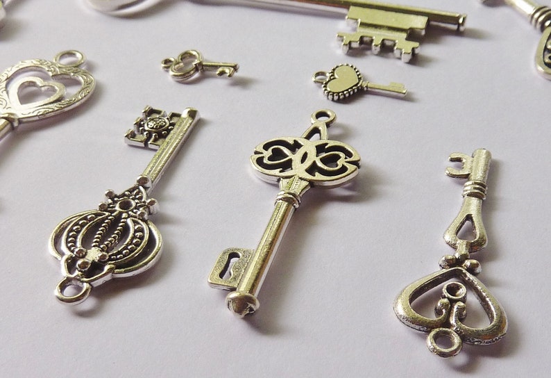 May include: Assortment of silver-toned skeleton keys with ornate designs. The keys have different shapes and sizes, including heart-shaped keyholes and intricate details.